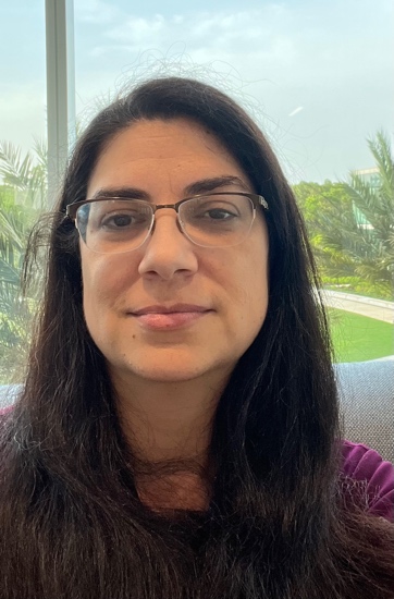 A person with glasses and a purple shirt
Description automatically generated